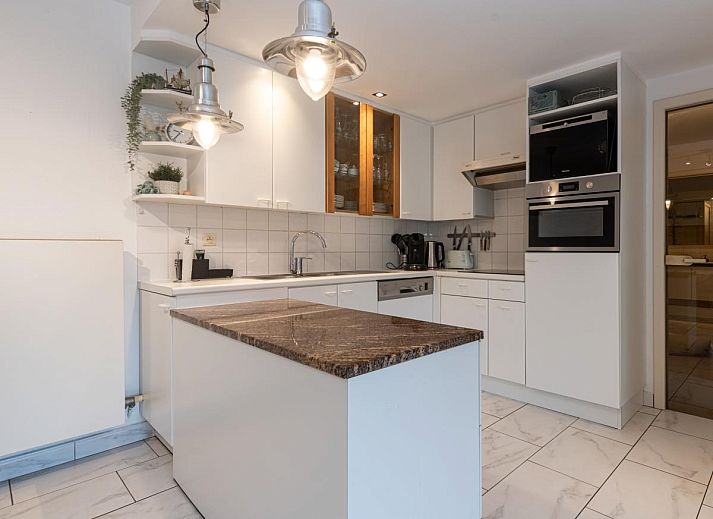 Gezellige woonkamer in vakantiehuis Reigersnest, Nieuwpoort, Belgische kust, met comfortabele zithoek en uitzicht op groene omgeving.