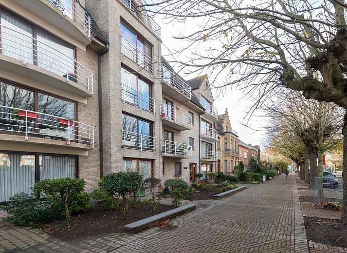 Gezellige woonkamer in vakantiehuis Reigersnest, Nieuwpoort, Belgische kust, met comfortabele zithoek en uitzicht op groene omgeving.