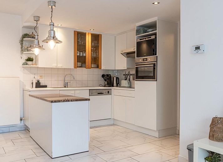 Moderne woonkamer van vakantiehuis Reigersnest in Nieuwpoort, Belgische kust, met stijlvolle inrichting en ruime open keuken.