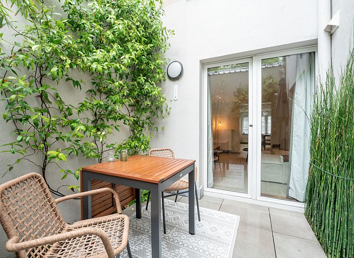 Gezellige woonkamer van Appartement Villa George in Oostende, Belgische kust, met modern interieur en toegang tot een zonnig terras.