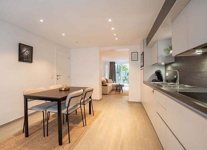 Gezellige woonkamer van Appartement Villa George in Oostende, Belgische kust, met modern interieur en toegang tot een zonnig terras.