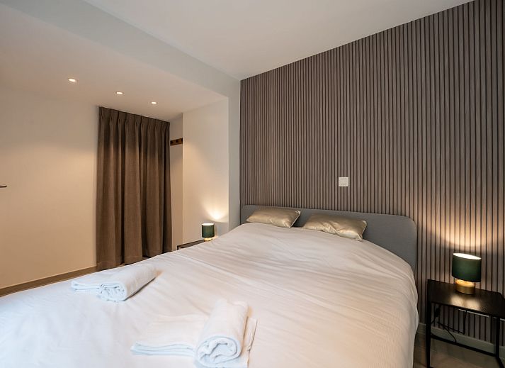 Gezellige woonkamer van Appartement Villa George in Oostende, Belgische kust, met modern interieur en toegang tot een zonnig terras.