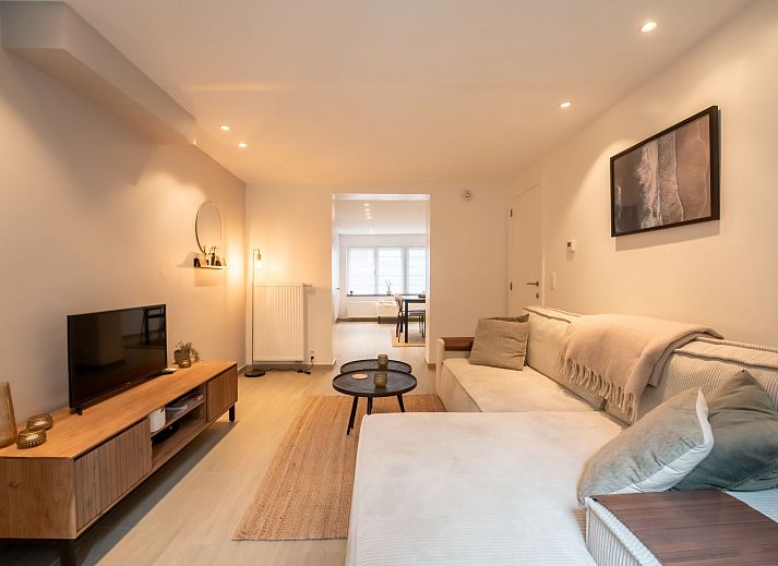 Gezellig terras bij Appartement Villa George in Oostende, Belgische kust, met comfortabele zitplek en groene accenten.