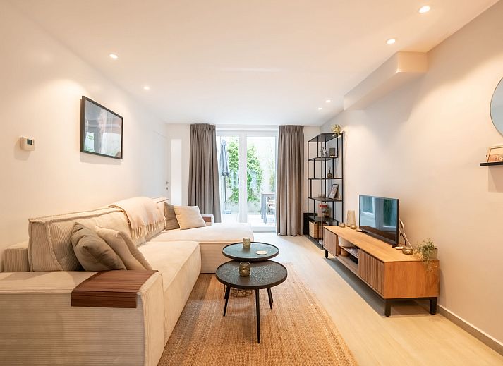 Gezellig terras bij Appartement Villa George in Oostende, Belgische kust, met comfortabele zitplek en groene accenten.