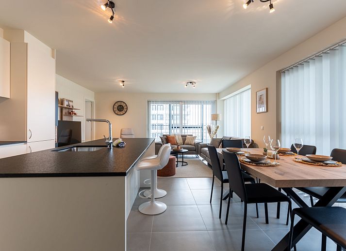 Lichte en ruime woonkamer van Appartement THe Waves in Oostende, Belgische kust, met moderne keuken en eethoek voor een comfortabel verblijf.