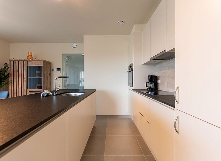 Lichte en ruime woonkamer van Appartement THe Waves in Oostende, Belgische kust, met moderne keuken en eethoek voor een comfortabel verblijf.