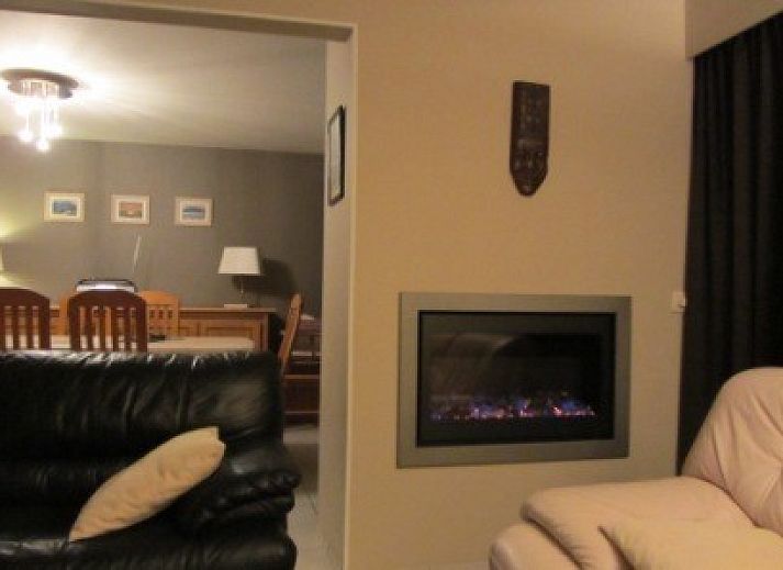 Gezellige woonkamer van De Viebarke vakantiehuis in Nieuwpoort-Bad, Belgische kust, met uitzicht op de groene tuin.