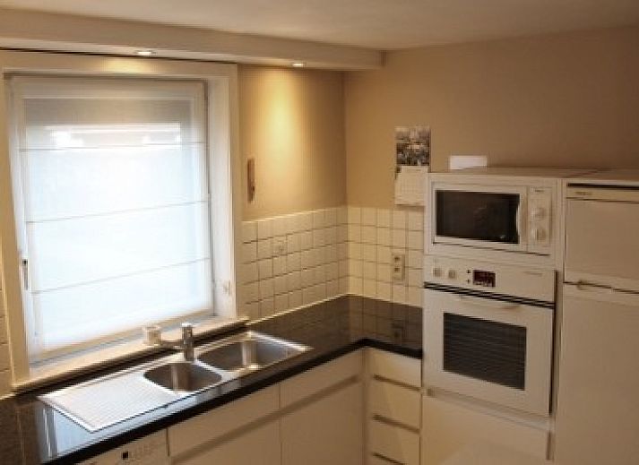 Sfeervolle zithoek met open haard in De Viebarke vakantiewoning, Nieuwpoort-Bad, Belgische kust.