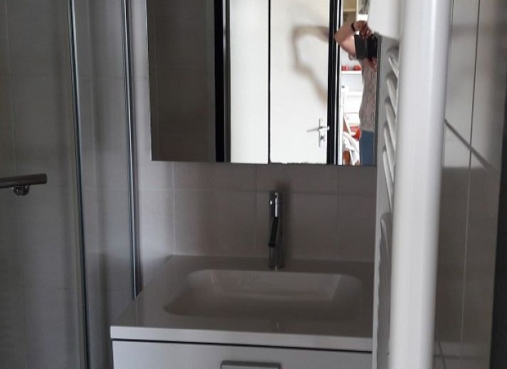 Lichte woonkamer van appartement Nieuwpoort-Bad aan de Belgische kust, met comfortabele zithoek en uitzicht op de omgeving.