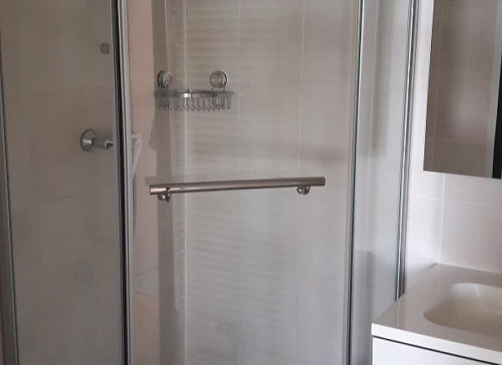 Lichte woonkamer van appartement Nieuwpoort-Bad aan de Belgische kust, met comfortabele zithoek en uitzicht op de omgeving.