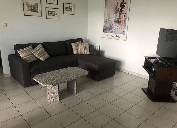 Dining area in Topaze apartment, De Panne, Belgian coast, with large windows and wooden closet.