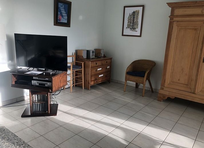 Dining area in Topaze apartment, De Panne, Belgian coast, with large windows and wooden closet.