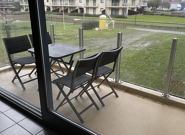 Dining area in Topaze apartment, De Panne, Belgian coast, with large windows and wooden closet.