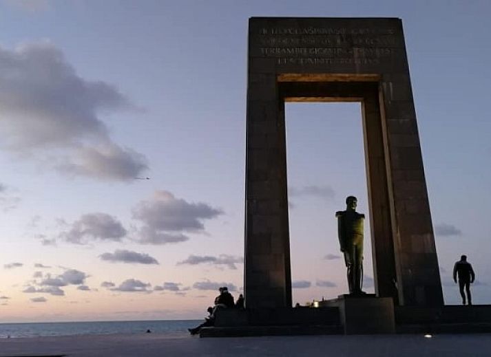 Spacious living room in apartment Topaze, De Panne, equipped with television and wooden furniture.