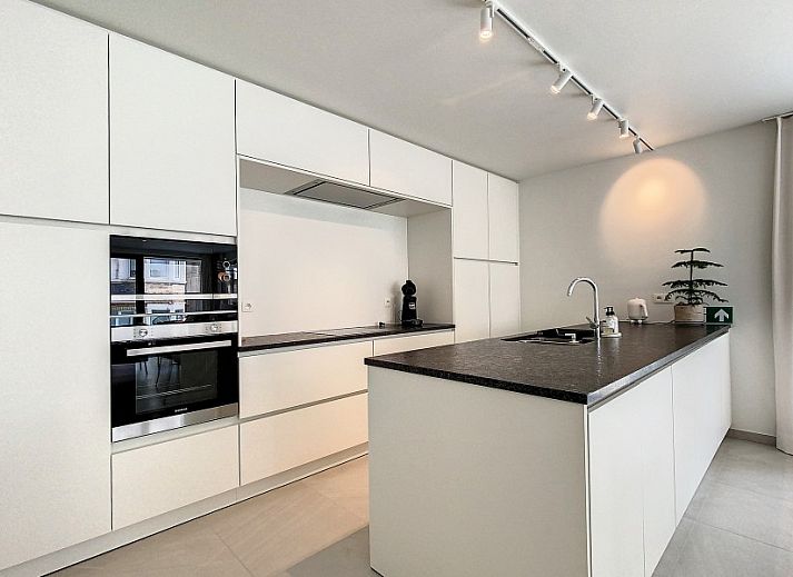 Modern living room in Apartment 'Asterias', De Panne, with comfortable seating area and large windows.