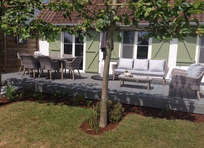 Entspannen Sie sich auf der Terrasse des Ferienhauses Windekind mit Blick auf die Felder in De Panne an der belgischen Kueste, mit bequemen Sitzgelegenheiten und Blick auf den Garten.