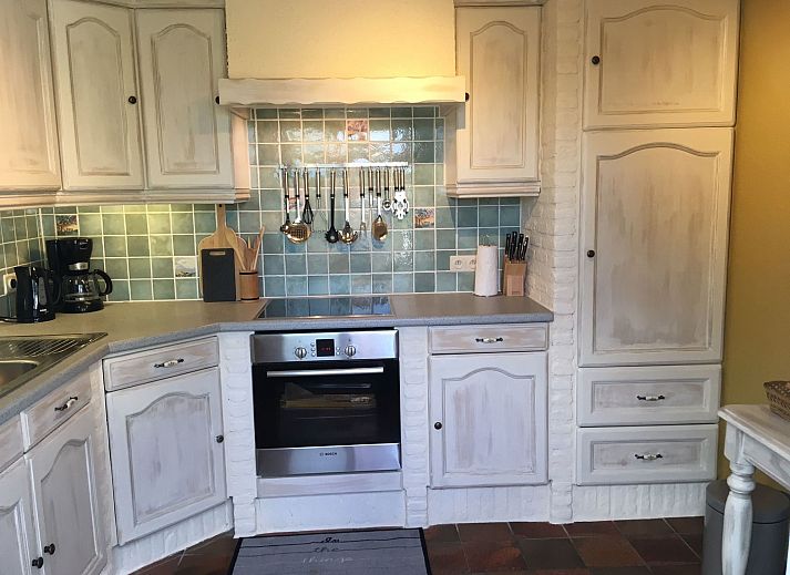 Gemuetliches Schlafzimmer im Ferienhaus Windekind mit bequemem Sofa und stimmungsvoller Beleuchtung, gelegen in De Panne an der belgischen Kueste.