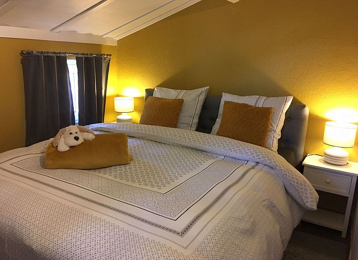 Gemuetliches Schlafzimmer im Ferienhaus Windekind mit Blick auf die Felder, De Panne, belgische Kueste, mit Holzausstattung und bequemen Betten.