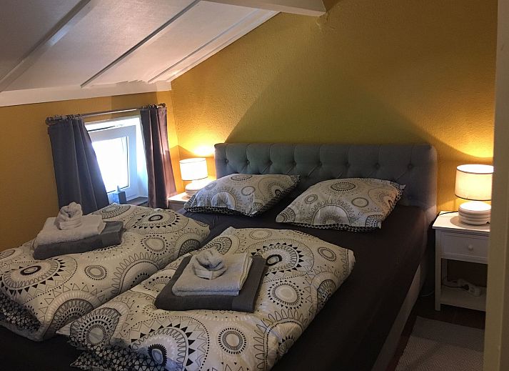 Gemuetliches Schlafzimmer im Ferienhaus Windekind mit Blick auf die Felder, De Panne, belgische Kueste, mit Holzausstattung und bequemen Betten.