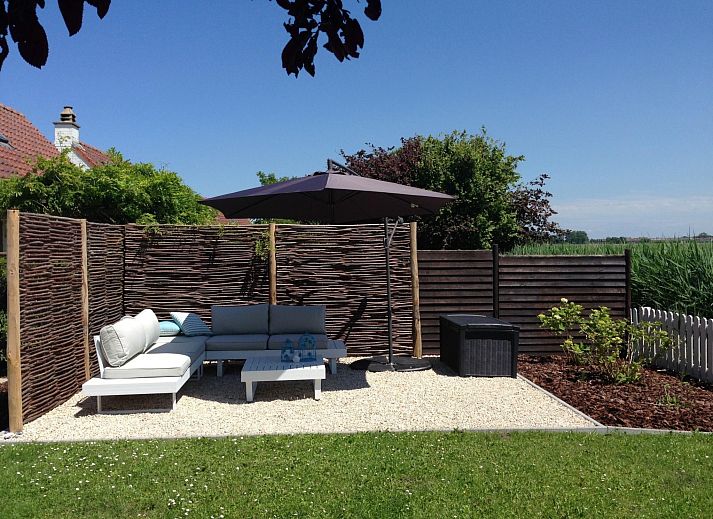 Geniessen Sie die Sonne auf der Terrasse des Ferienhauses Polderwind mit Blick auf die Felder in De Panne, Belgische Kueste, Belgien.