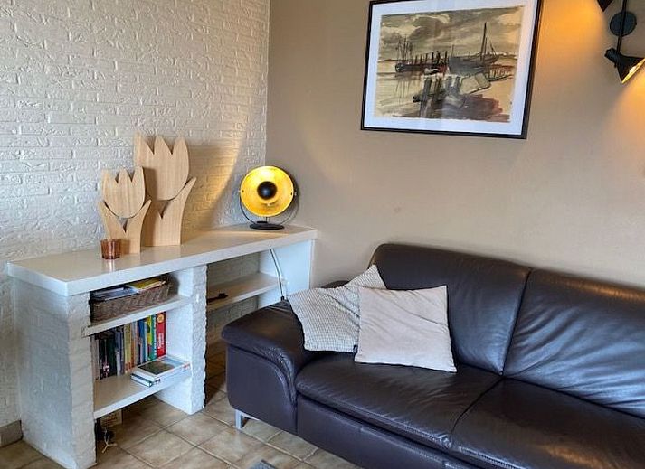 Gemuetliches Wohnzimmer im Ferienhaus mit Pool, gelegen in De Panne an der belgischen Kueste, mit komfortabler Sitzecke und gemuetlicher Einrichtung.