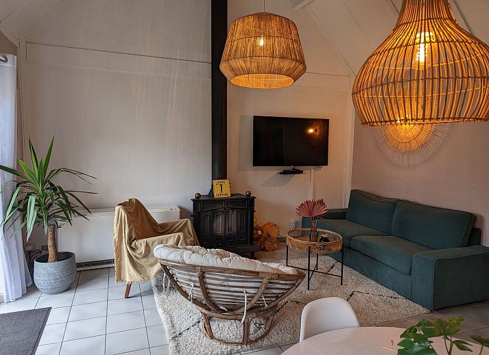 Gemuetliches Wohnzimmer im Ferienhaus Duinendaele II, De Panne, belgische Kueste, mit stimmungsvoller Beleuchtung und bequemer Sitzecke.