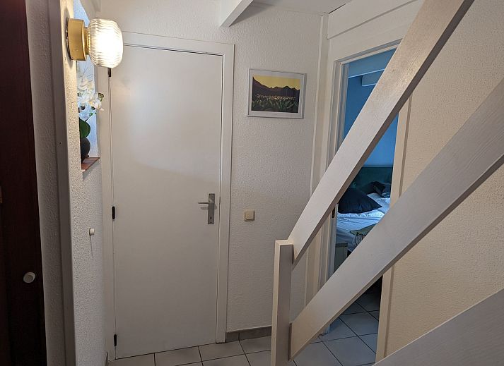 Gemuetliches Wohnzimmer im Ferienhaus Duinendaele II, De Panne, belgische Kueste, mit stimmungsvoller Beleuchtung und bequemer Sitzecke.