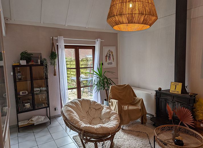 Gemuetliches Wohnzimmer im Ferienhaus Duinendaele II, De Panne, belgische Kueste, mit stimmungsvoller Beleuchtung und bequemer Sitzecke.