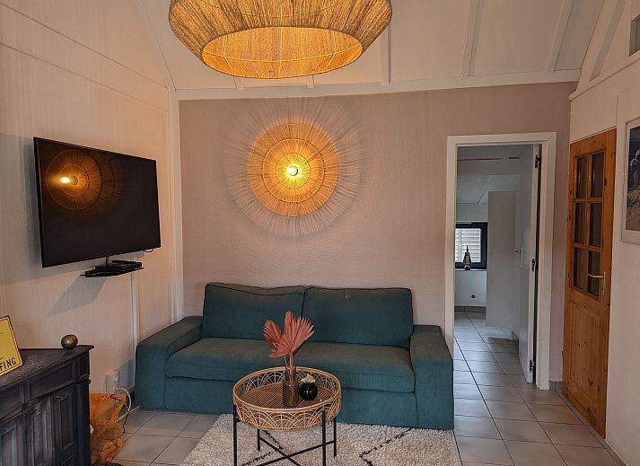 Gemuetliches Wohnzimmer im Ferienhaus Duinendaele II, De Panne, belgische Kueste, mit stimmungsvoller Beleuchtung und bequemer Sitzecke.