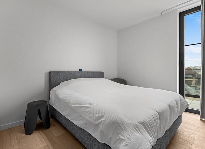 Modern living room of Penthouse 'Ter Elst' in De Panne, Belgian coast, with a view of nature from the terrace.