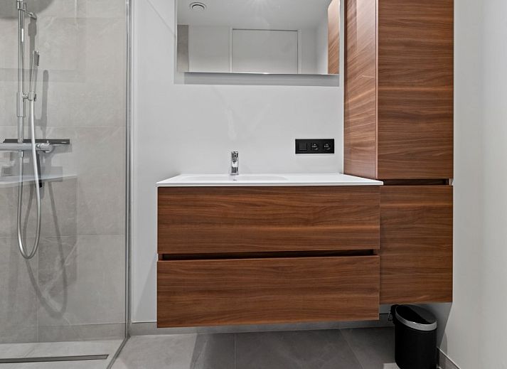 Modern living room of Penthouse 'Ter Elst' in De Panne, Belgian coast, with a view of nature from the terrace.
