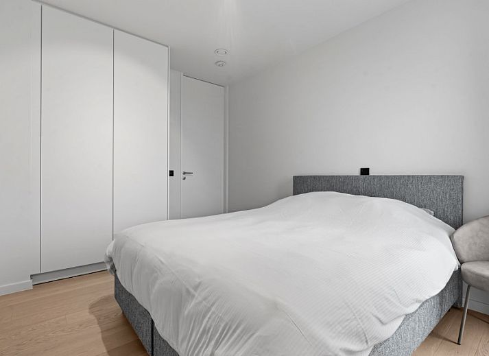 Modern living room of Penthouse 'Ter Elst' in De Panne, Belgian coast, with a view of nature from the terrace.