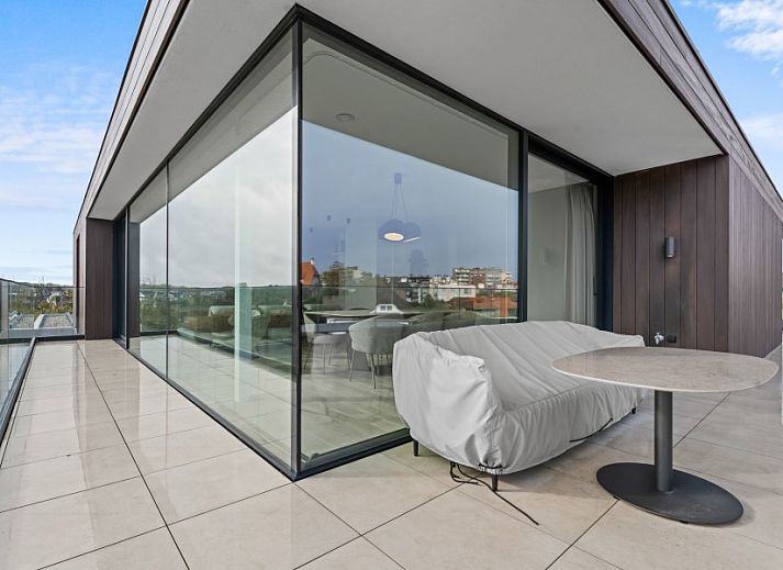 Modern living room of Penthouse 'Ter Elst' in De Panne, Belgian coast, with a view of nature from the terrace.