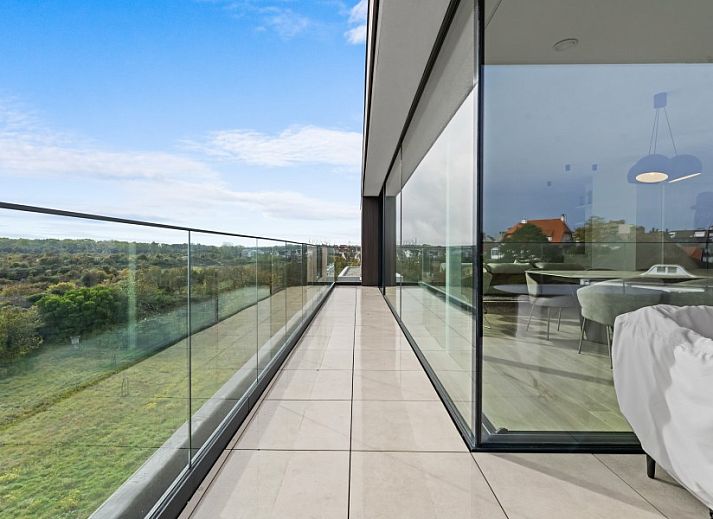Modern living room of Penthouse 'Ter Elst' in De Panne, Belgian coast, with a view of nature from the terrace.