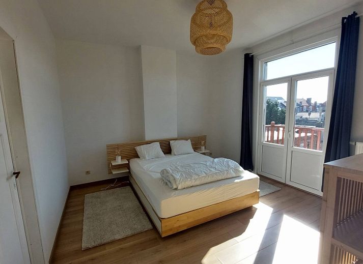 Gemuetliches Schlafzimmer im Ferienhaus "De Zji" in De Panne an der belgischen Kueste, mit grossem Fenster und moderner Einrichtung fuer einen entspannten Aufenthalt.