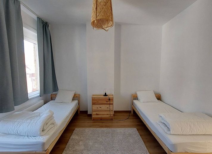 Gemuetliches Schlafzimmer im Ferienhaus "De Zji" in De Panne an der belgischen Kueste, mit grossem Fenster und moderner Einrichtung fuer einen entspannten Aufenthalt.