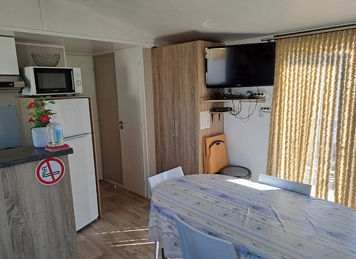 Veranda van Vakantieverblijf Wenduine, stacaravan in Wenduine, Belgische kust, met houten terras en parasol.