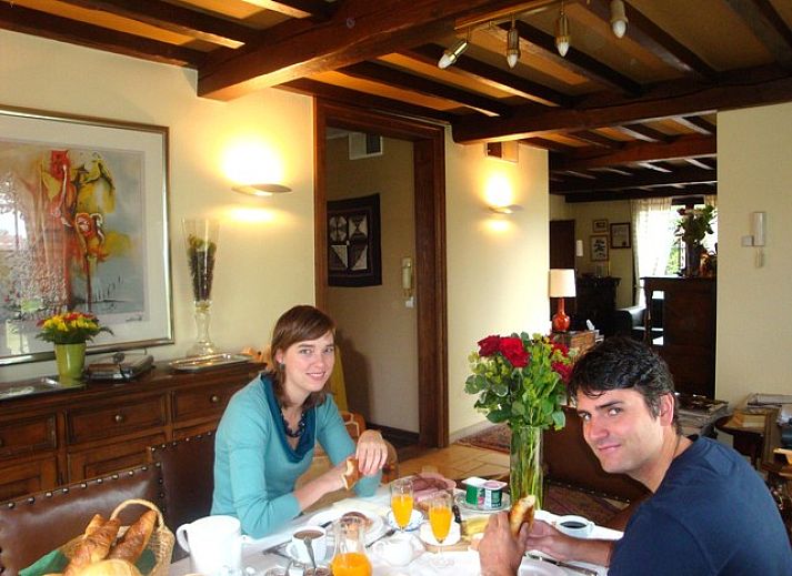 Cozy living room in B & B YACA, De Haan, with wooden beams and an inviting atmosphere.