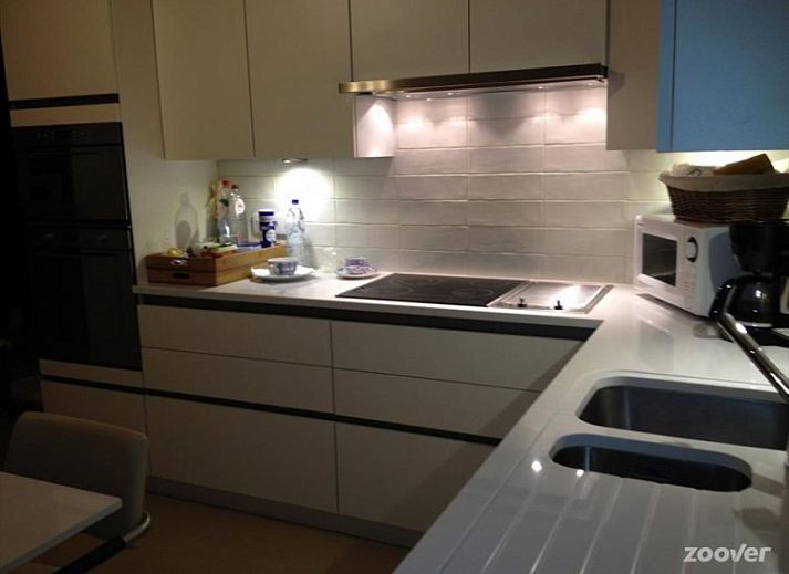 Cozy living room in B & B YACA, De Haan, with wooden beams and an inviting atmosphere.