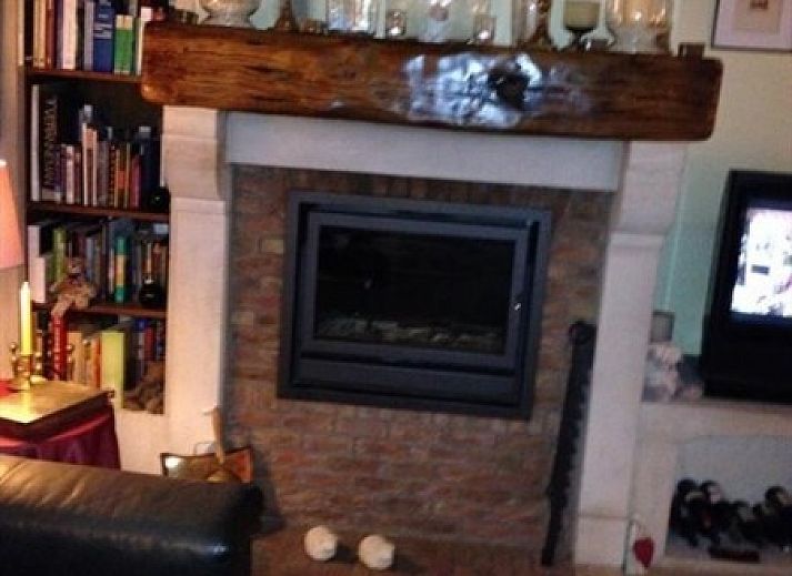 Cozy living room in B & B YACA, De Haan, with wooden beams and an inviting atmosphere.