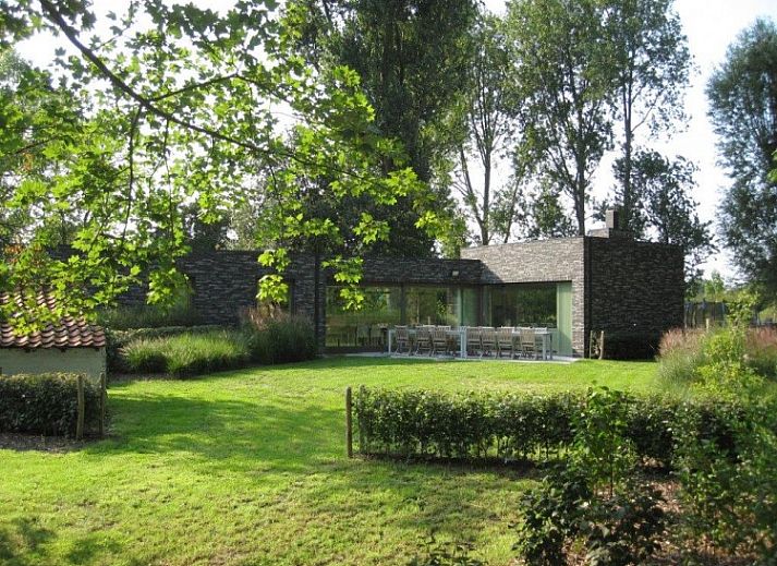 Gezellige woonkamer in Duinpaviljoen vakantiehuis met ruime ramen in Koksijde, Belgische kust.