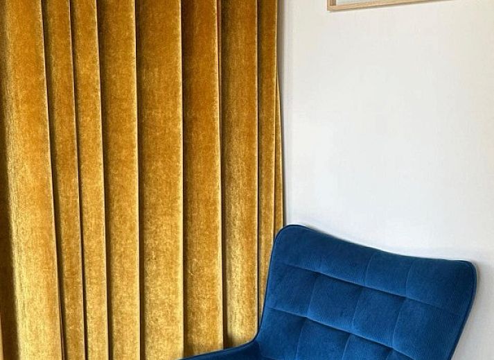 Gezellige woonkamer in Duinpaviljoen vakantiehuis met ruime ramen in Koksijde, Belgische kust.