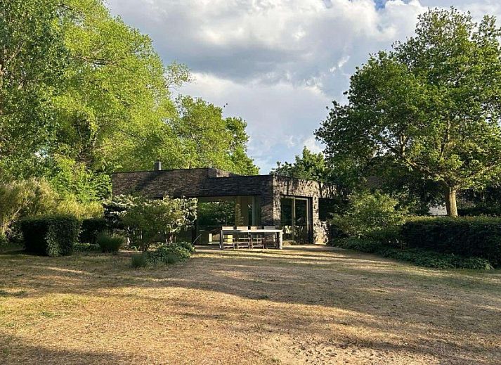 Gezellige woonkamer in Duinpaviljoen vakantiehuis met ruime ramen in Koksijde, Belgische kust.