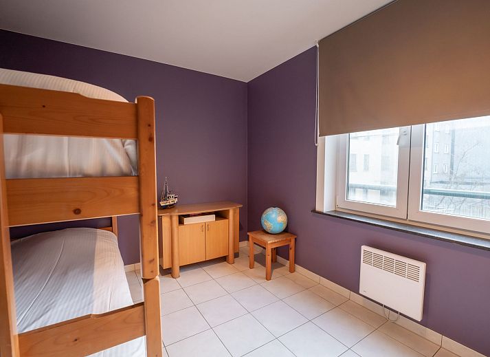 Sfeervolle slaapkamer in Appartement Flipper nabij het strand in De Haan, Belgische kust. Comfortabel verblijf met rustgevende inrichting.