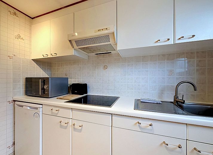 Moderne keuken in Vakantiehuis Edelweiss with parking in De Haan, Belgische kust, met witte kasten en ruime werkruimte.