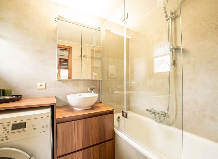 Moderne badkamer in Vakantiehuis Edelweiss met wasmachine, gelegen in De Haan aan de Belgische kust.
