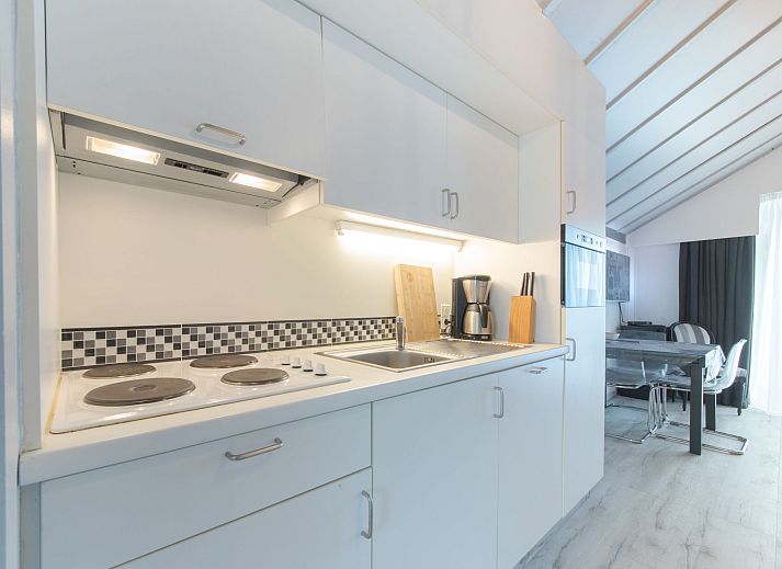 Stijlvolle binnenruimte van Appartement La Bella Vita in De Haan, Belgische kust, met modern interieur en eetgedeelte.