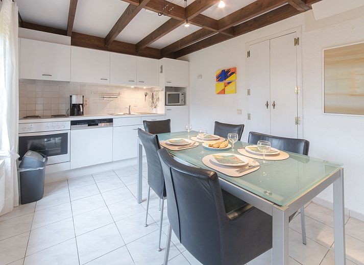 Gezellige woonkamer in Vakantiehuis V54 met open haard en comfortabele zithoek, gelegen in De Haan aan de Belgische kust.