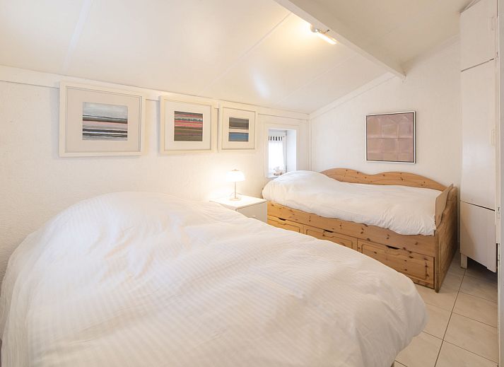 Gezellige woonkamer in Vakantiehuis V54 met open haard en comfortabele zithoek, gelegen in De Haan aan de Belgische kust.