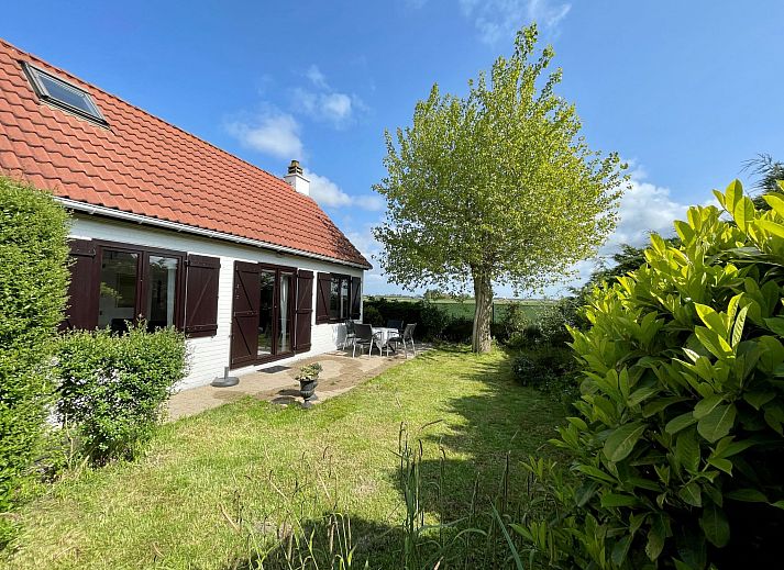 Gezellige woonkamer in Vakantiehuis V54 met open haard en comfortabele zithoek, gelegen in De Haan aan de Belgische kust.